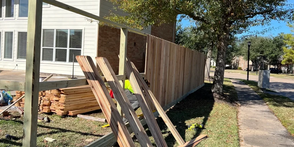 Professional wood fence installation in progress for a residential home
