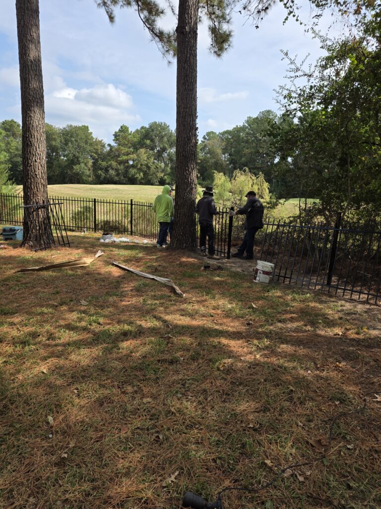 Contractors installing a metal security fence.