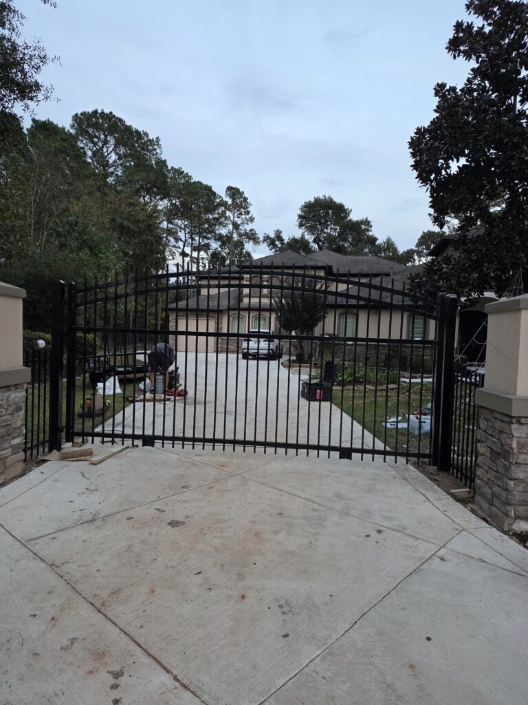 Wrought iron security fence installation in a driveway.