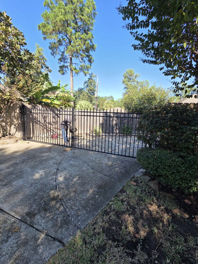 Wrought iron security fence installation in a driveway.