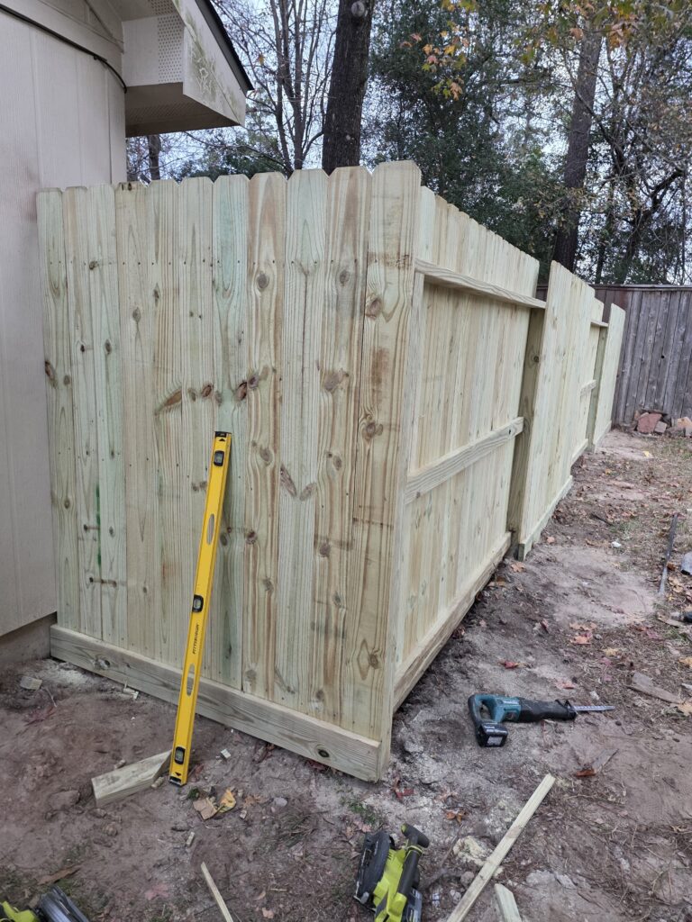 Yellow safety handrail installation on a concrete loading dock ramp.