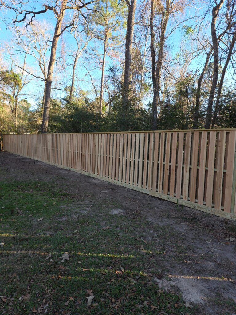 Wooden vertical board fence along property line.